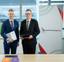 Australian Attorney-General’s Department: Co-Director of the Commonwealth Fraud Prevention Centre (the Centre) and secondee Christopher McDermott (left) and Deputy Secretary Simon Newnham (right) are photographed in front the Centre banner.